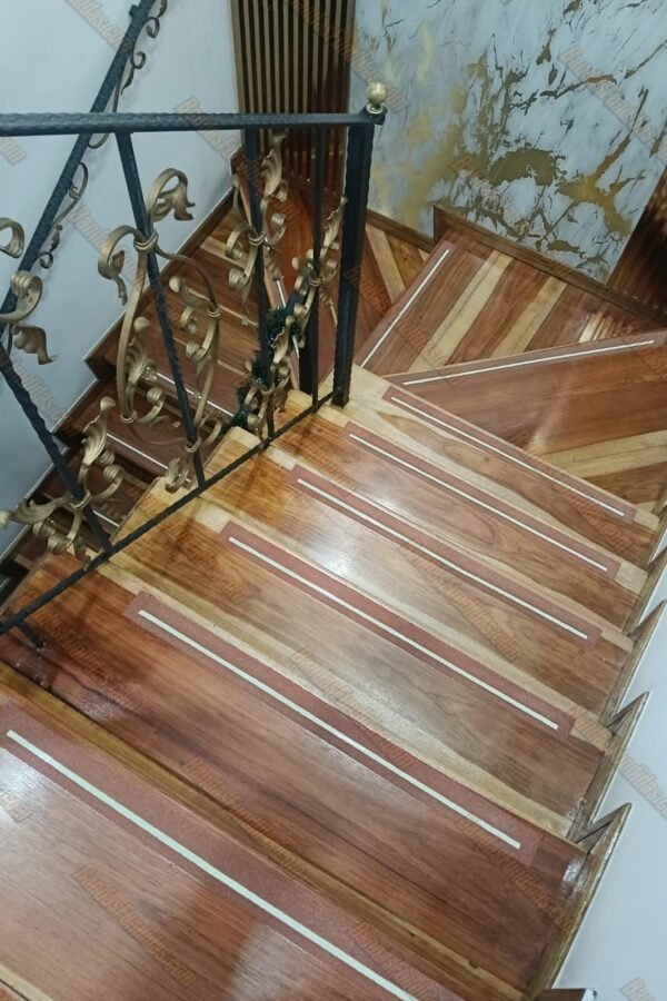 Detalle de banda antideslizante fundida con línea fotoluminiscente integrada estéticamente en escalones de madera para acabados de lujo.