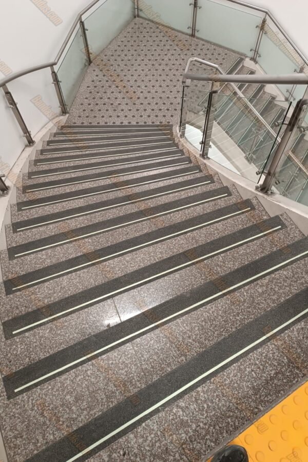 Instalación de bandas fundidas antideslizantes en escaleras lisas de centros comerciales para garantizar la seguridad de los visitantes.