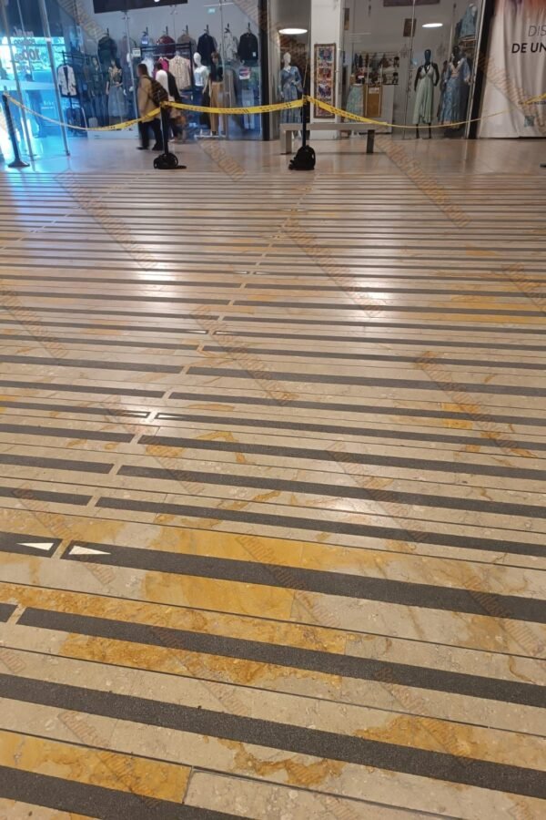 Instalación masiva de bandas fundidas antideslizantes en pisos lisos de centros comerciales para garantizar la seguridad de los visitantes.