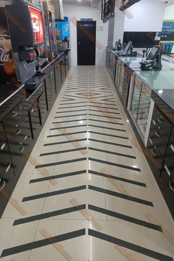 Diseño direccional con bandas antideslizantes fundidas en piso de alto tráfico para zona de comidas y cines en Bogotá.
