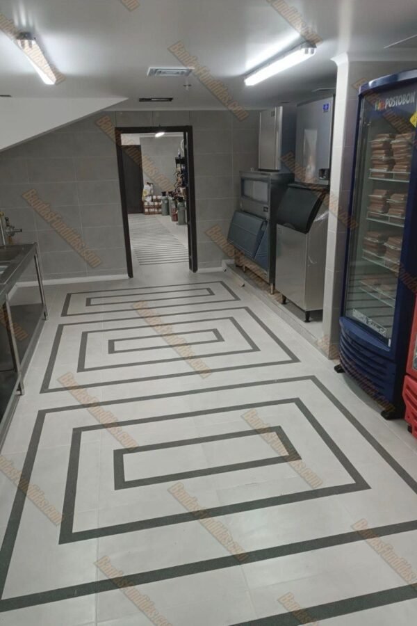 Diseño geométrico con bandas antideslizantes fundidas en piso de zona de preparación de alimentos y cuartos fríos para evitar accidentes laborales.